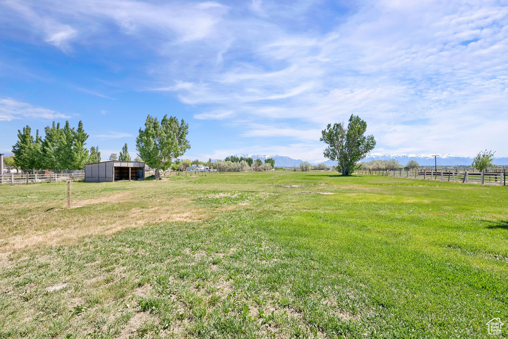 View of yard with a rural view, a pole building, a mountain view, and an outbuilding