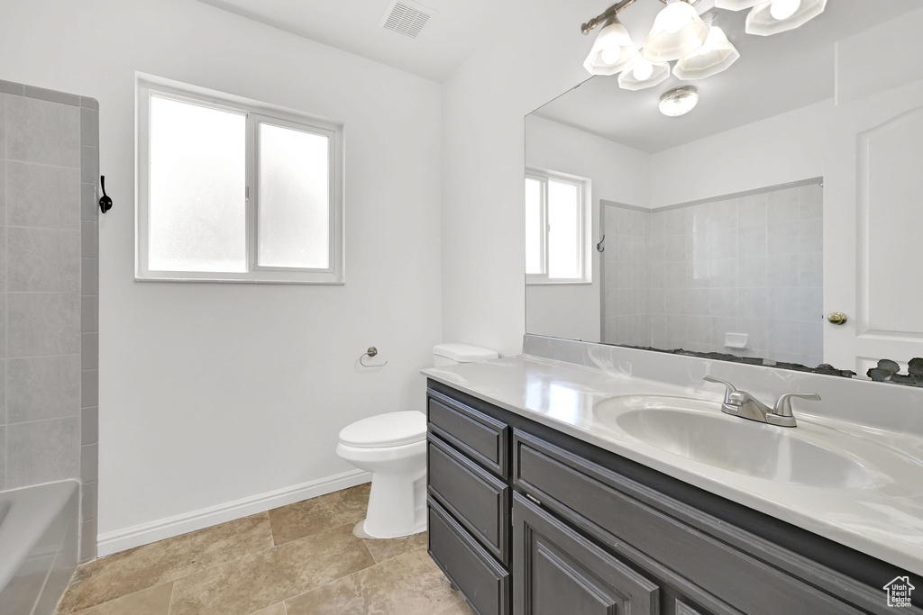 Bathroom featuring a chandelier, toilet, vanity, baseboards, and bathing tub / shower combination
