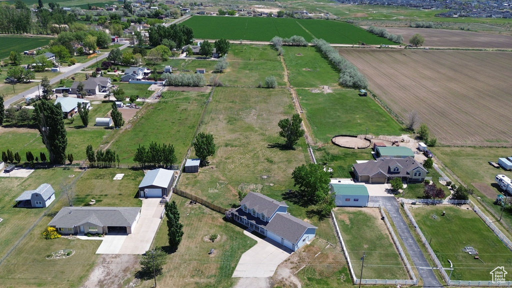 Aerial view of property and surrounding area featuring rural landscape and nearby suburban area