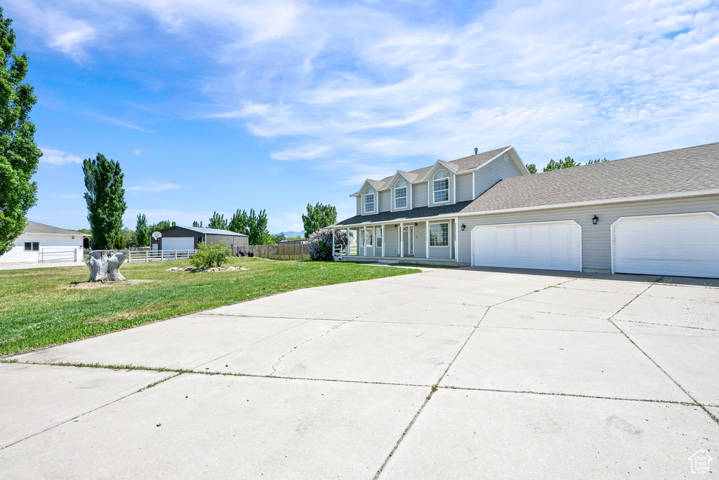 Traditional-style house featuring concrete driveway, an attached garage, and a porch