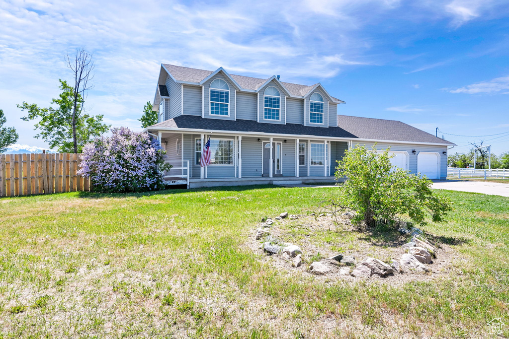 View of front of house featuring driveway, a porch, a garage, and a shingled roof