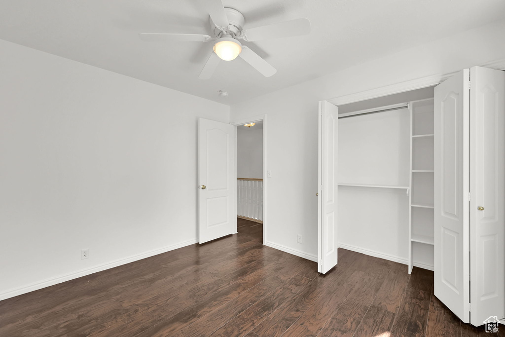 Unfurnished bedroom with wood finished floors, a closet, a ceiling fan, and baseboards