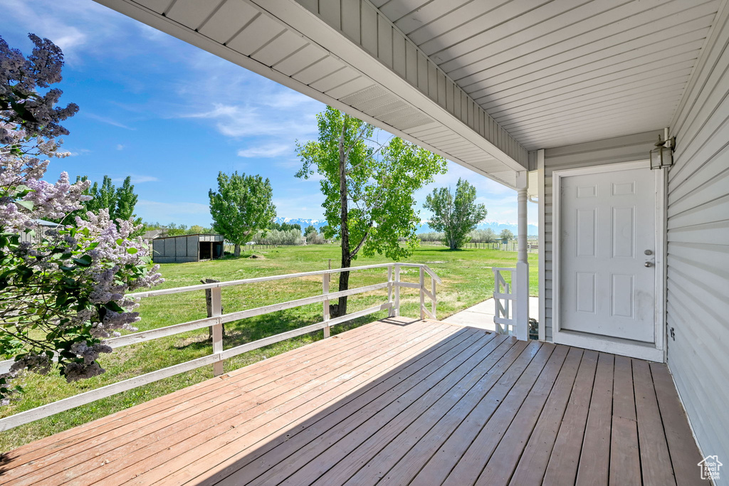 Deck featuring a lawn, a view of countryside, and an outbuilding