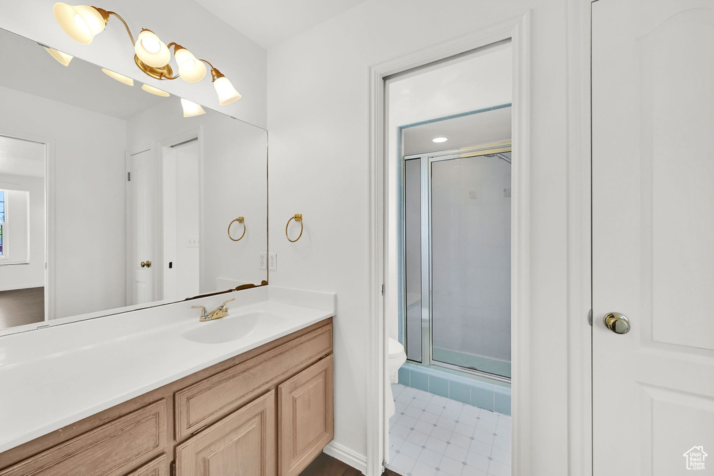 Full bathroom featuring toilet, a stall shower, and vanity