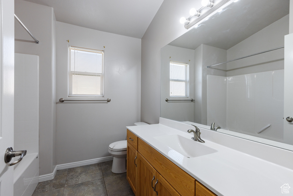 Full bathroom with baseboards, washtub / shower combination, toilet, and vanity