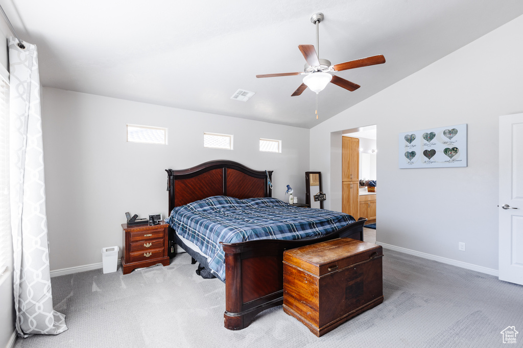 Carpeted bedroom featuring a ceiling fan, visible vents, vaulted ceiling, and baseboards