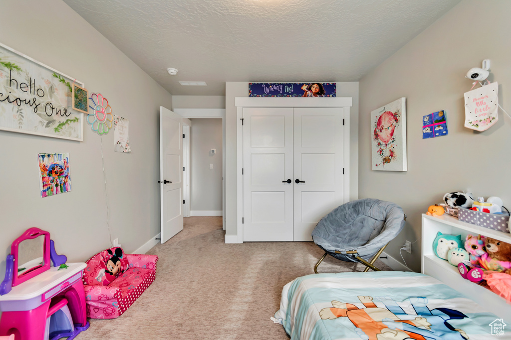 Carpeted bedroom featuring baseboards and a closet