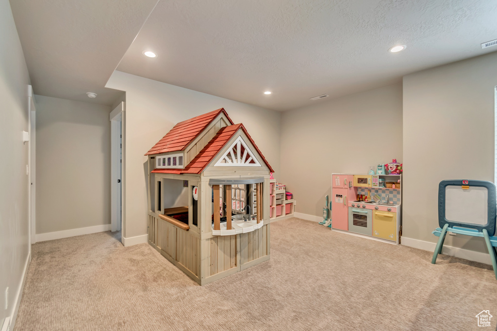 Recreation room with light carpet, recessed lighting, baseboards, and a textured ceiling
