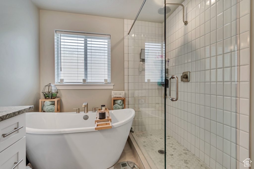 Bathroom with a shower stall, a freestanding tub, and vanity