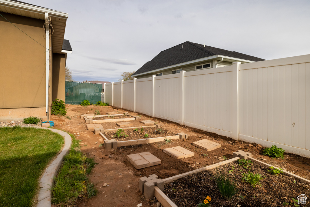 View of yard with a garden and fence