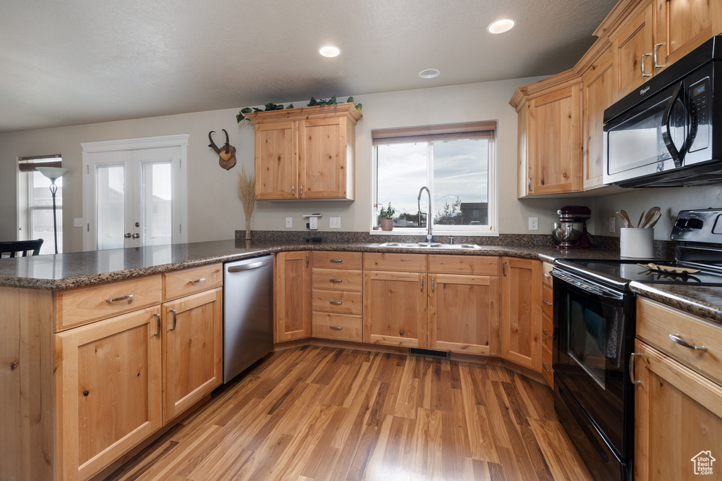 Kitchen featuring black appliances, a sink, a peninsula, healthy amount of natural light, and recessed lighting