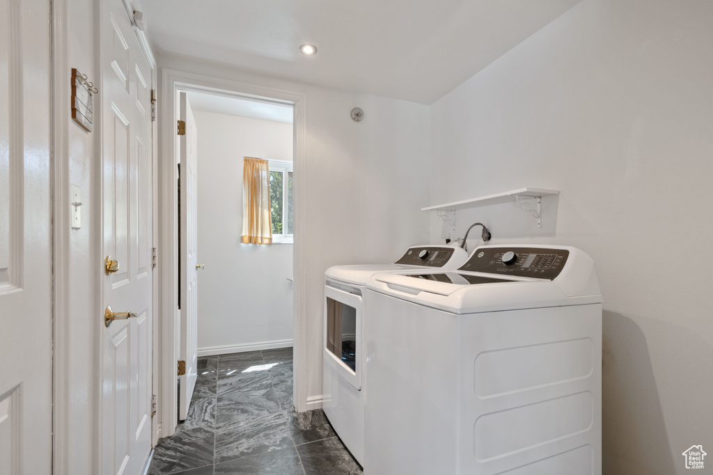 Laundry area featuring washing machine and clothes dryer, dark marble finish flooring, baseboards, and recessed lighting