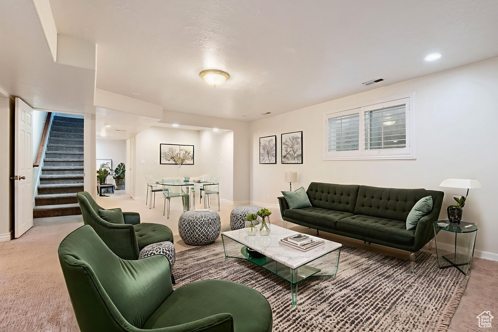 Living room featuring stairway, light colored carpet, and recessed lighting