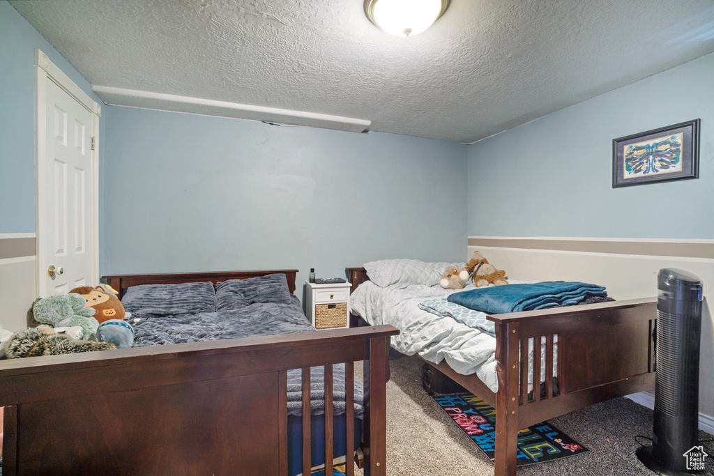 Bedroom with a textured ceiling and carpet floors