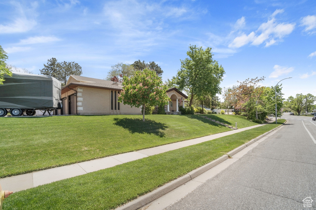 View of front of home featuring a front lawn and brick siding