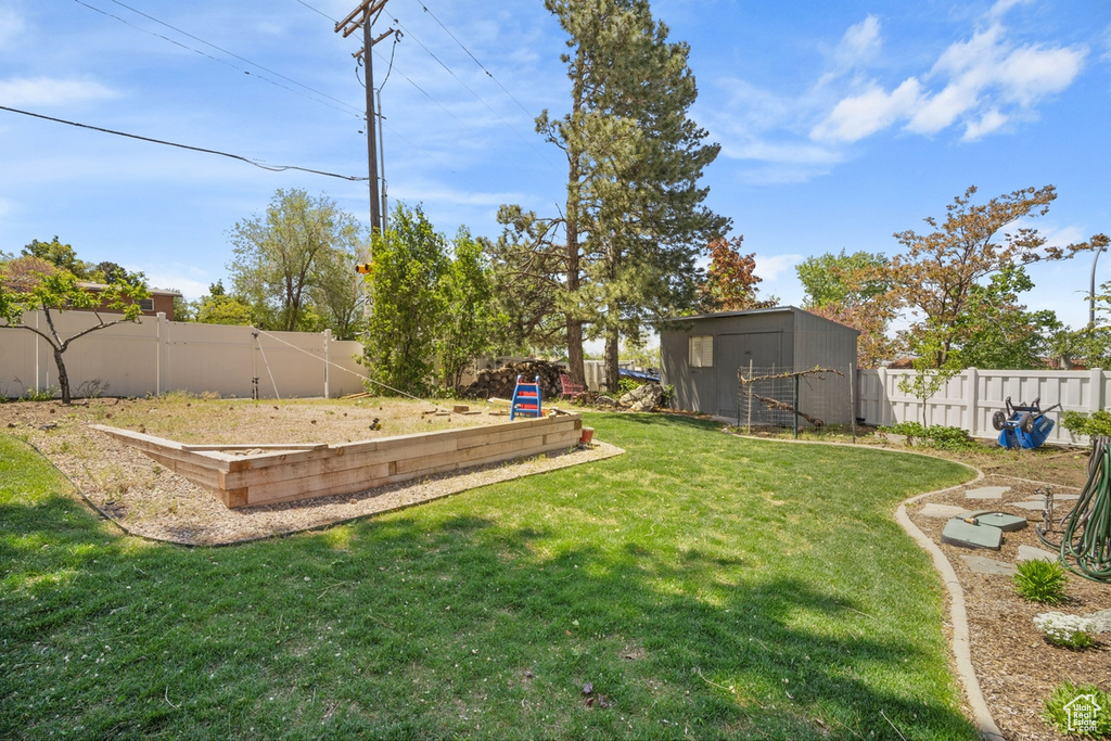 View of yard with a vegetable garden and an outdoor structure