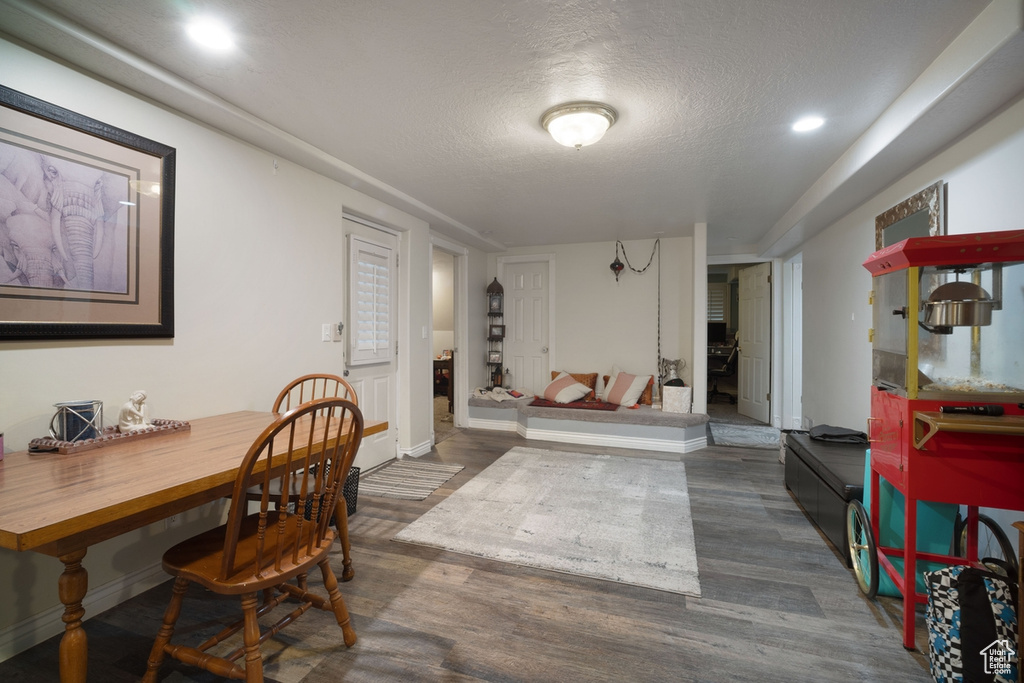 Dining room with dark wood-style flooring, baseboards, a textured ceiling, and recessed lighting