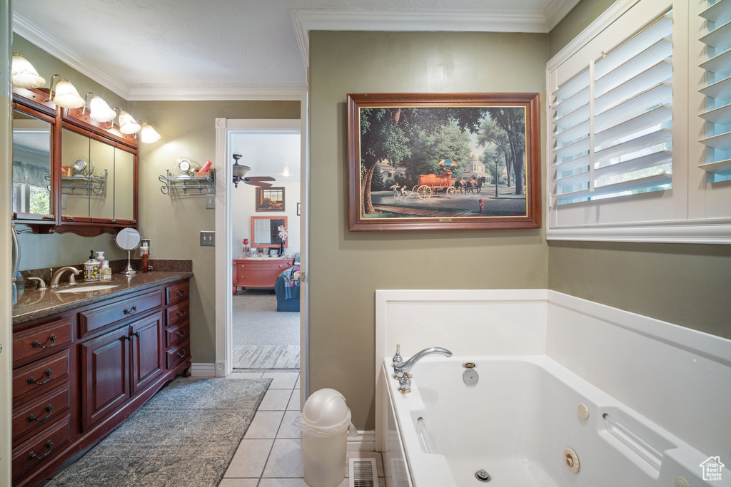 Bathroom with a tub with jets, vanity, tile patterned floors, and crown molding