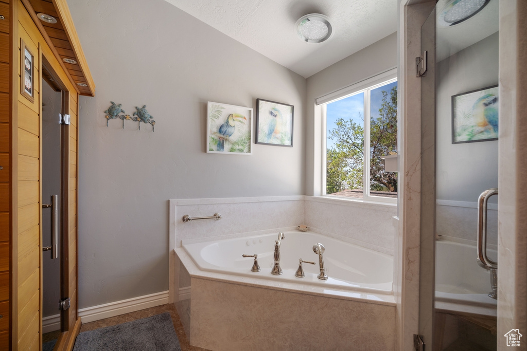 Full bathroom with a bath and vaulted ceiling