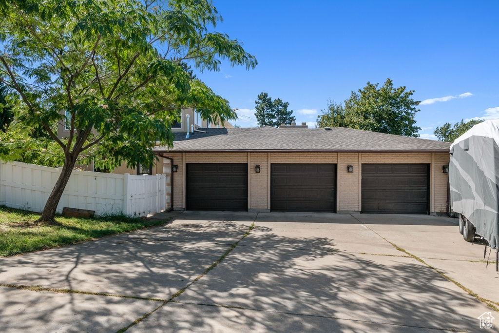 Garage with fence and concrete driveway