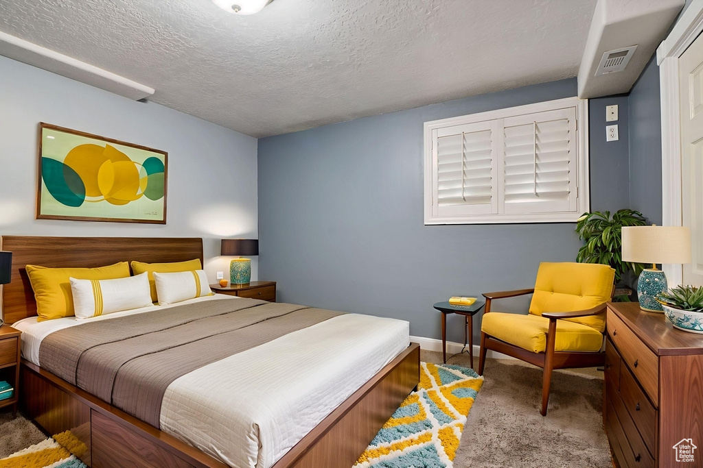 Bedroom with carpet and a textured ceiling
