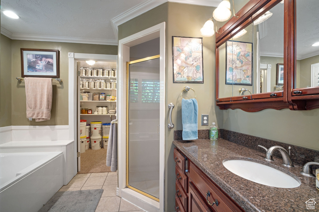 Full bathroom featuring a shower stall, crown molding, vanity, tile patterned floors, and a bath