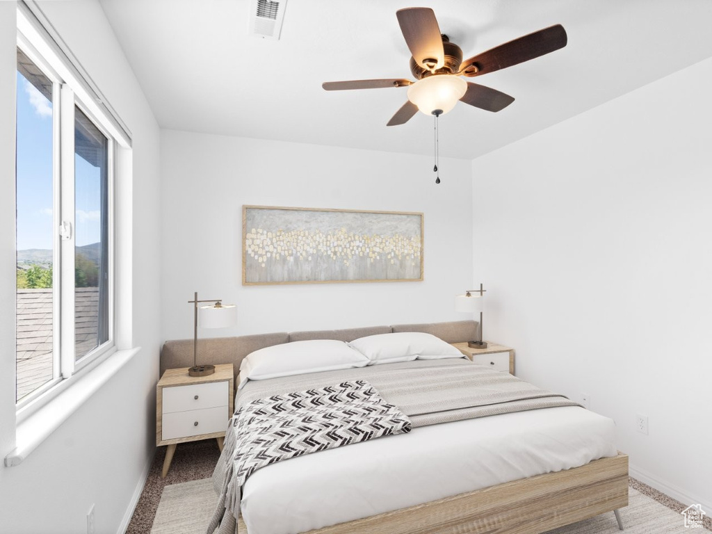 Carpeted bedroom featuring baseboards and a ceiling fan