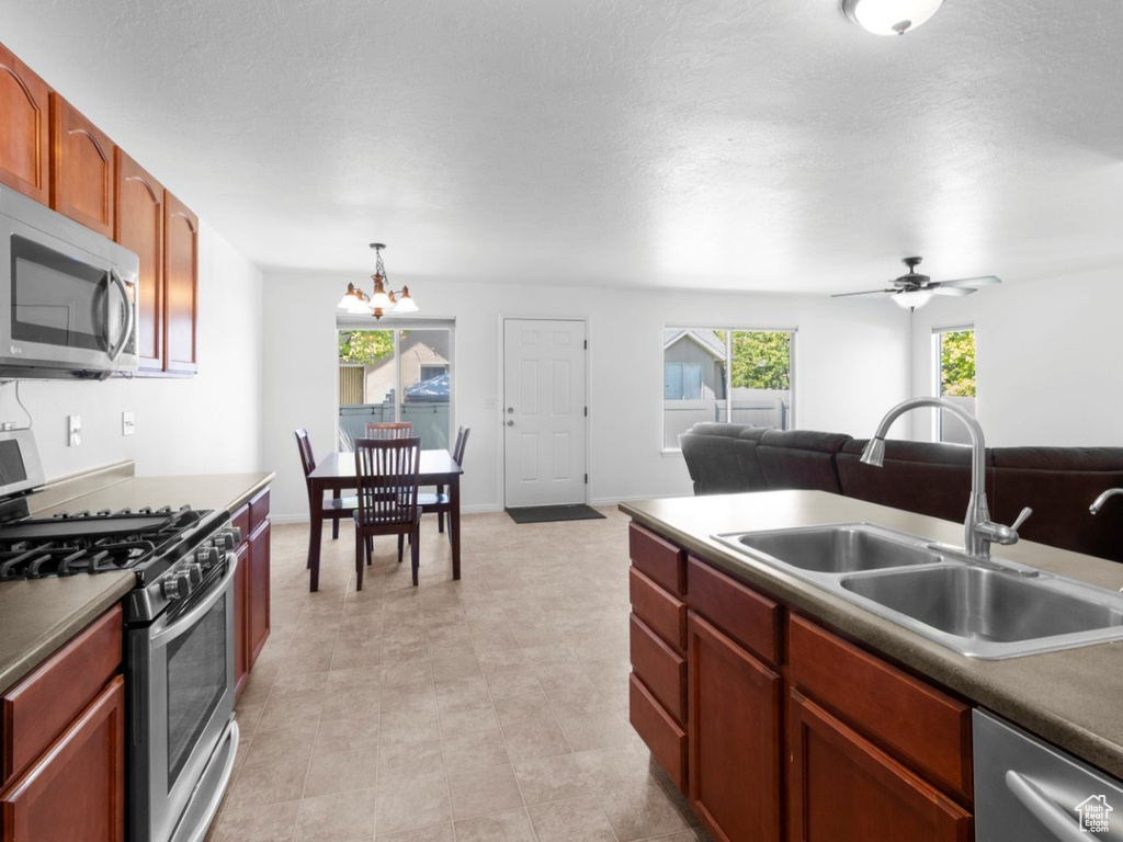 Kitchen with appliances with stainless steel finishes, a sink, a chandelier, and open floor plan
