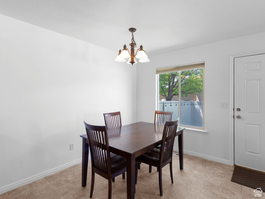 Dining space with a chandelier and baseboards