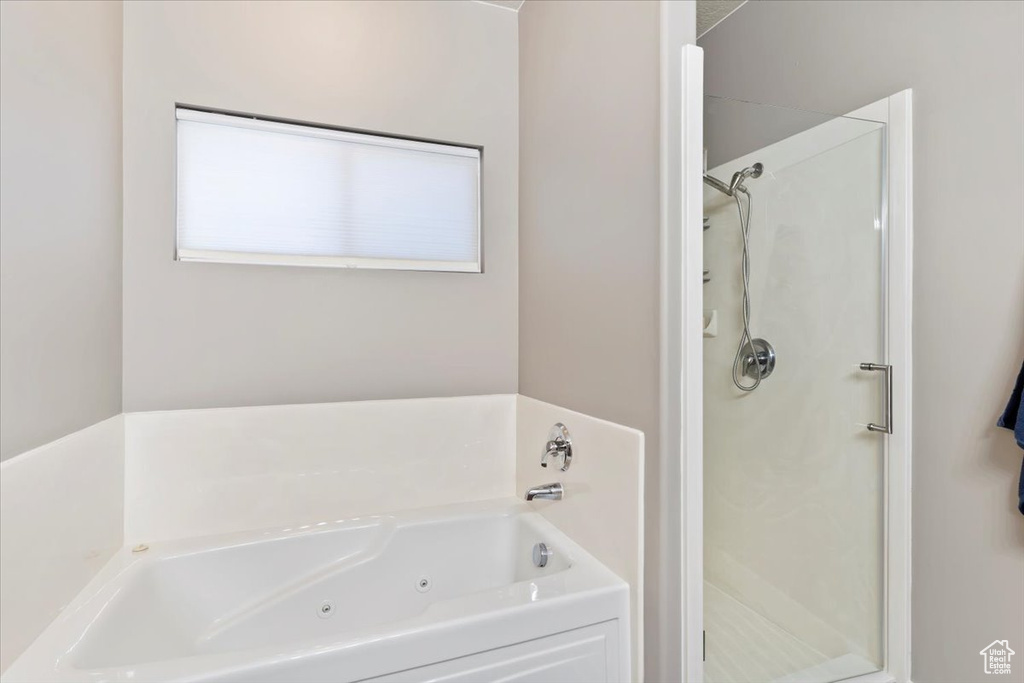 Full bath featuring a shower stall and a whirlpool tub