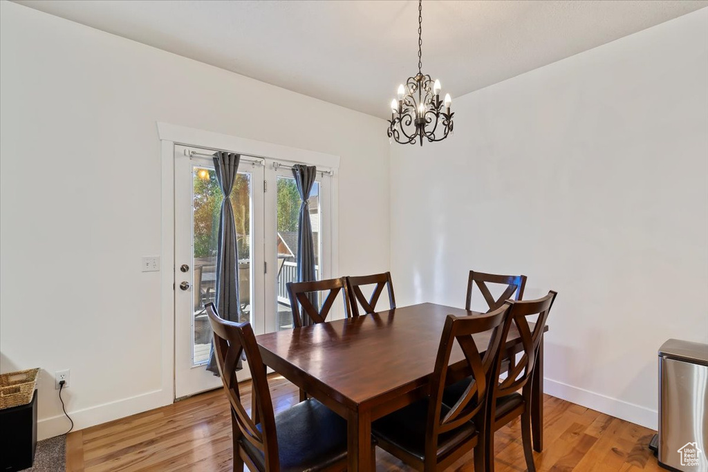 Dining space featuring a chandelier, baseboards, and light wood finished floors