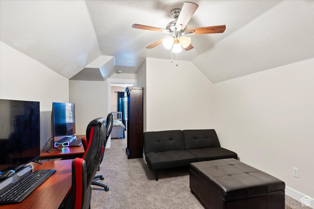 Office with vaulted ceiling, a ceiling fan, light colored carpet, and baseboards