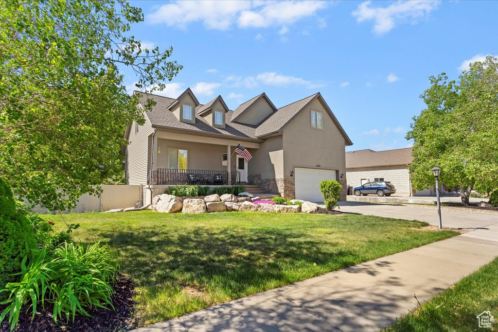 View of front of home featuring concrete driveway, an attached garage, stone siding, and stucco siding