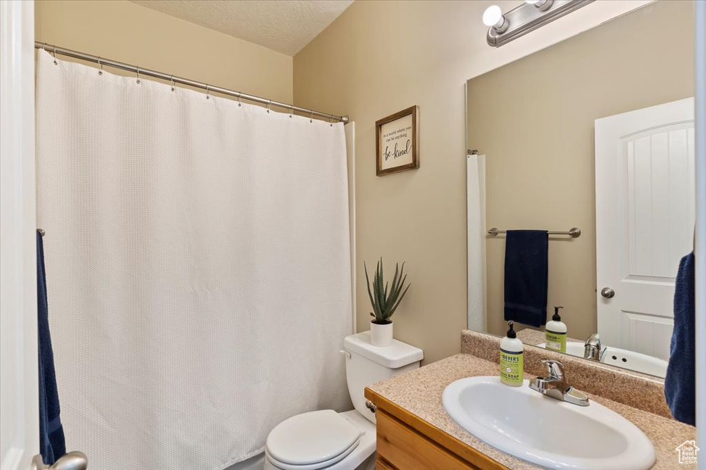 Full bath with toilet, vanity, and a shower with curtain