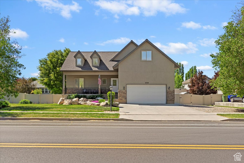 Traditional-style house with driveway, stucco siding, fence, and an attached garage