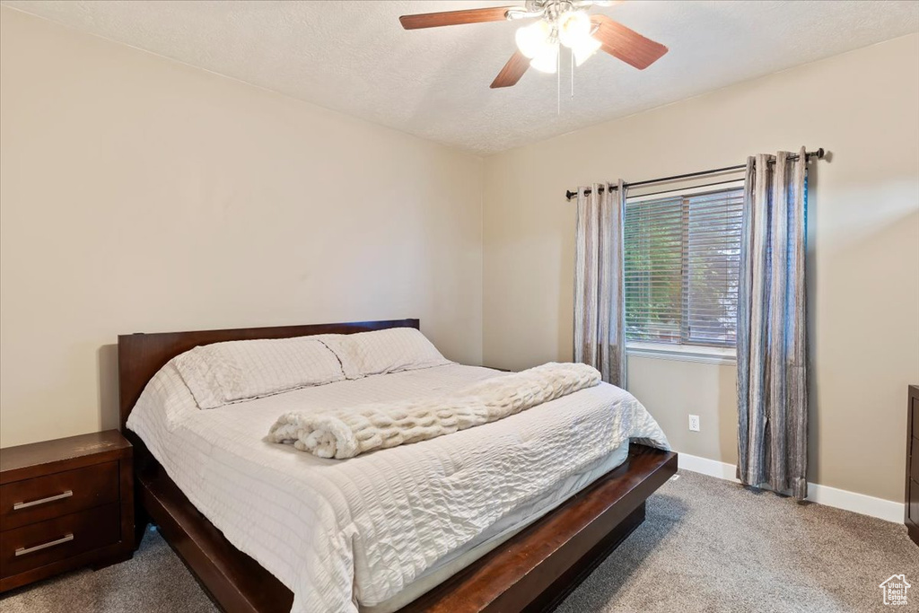 Carpeted bedroom with baseboards and a ceiling fan
