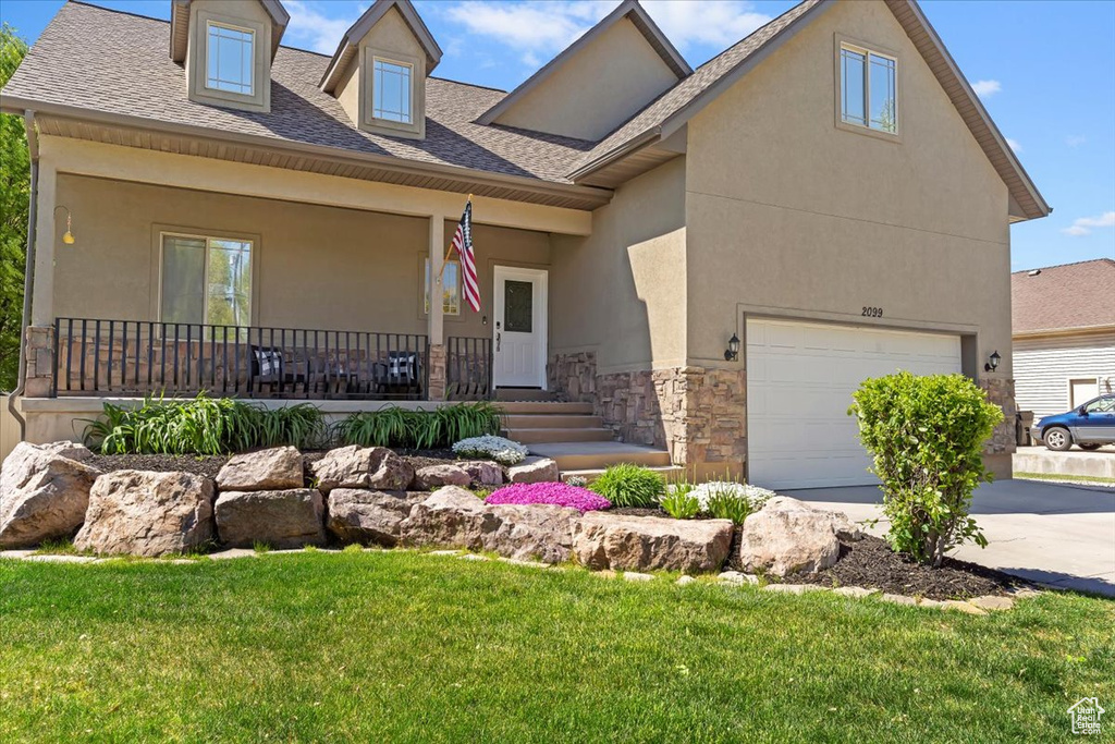 View of front facade with covered porch, concrete driveway, a shingled roof, stucco siding, and a garage