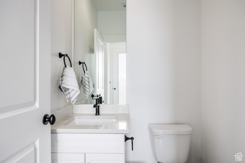 Half bathroom featuring toilet and vanity
