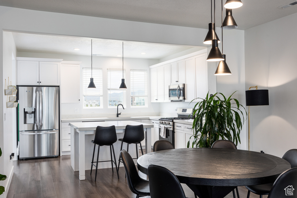 Dining area featuring dark wood-style flooring and recessed lighting