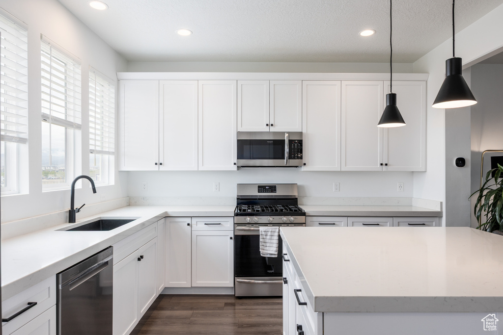 Kitchen featuring stainless steel appliances, a sink, recessed lighting, and white cabinetry