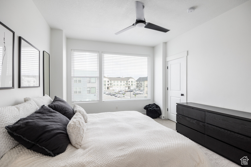 Carpeted bedroom featuring a ceiling fan
