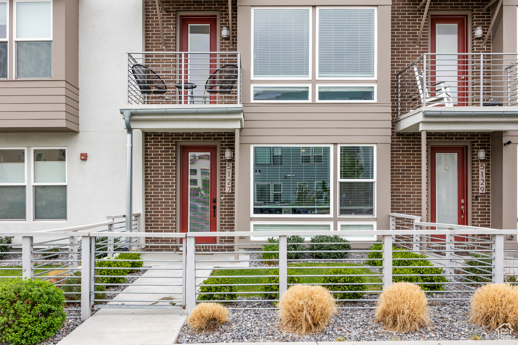 Entrance to property with brick siding, stucco siding, and fence
