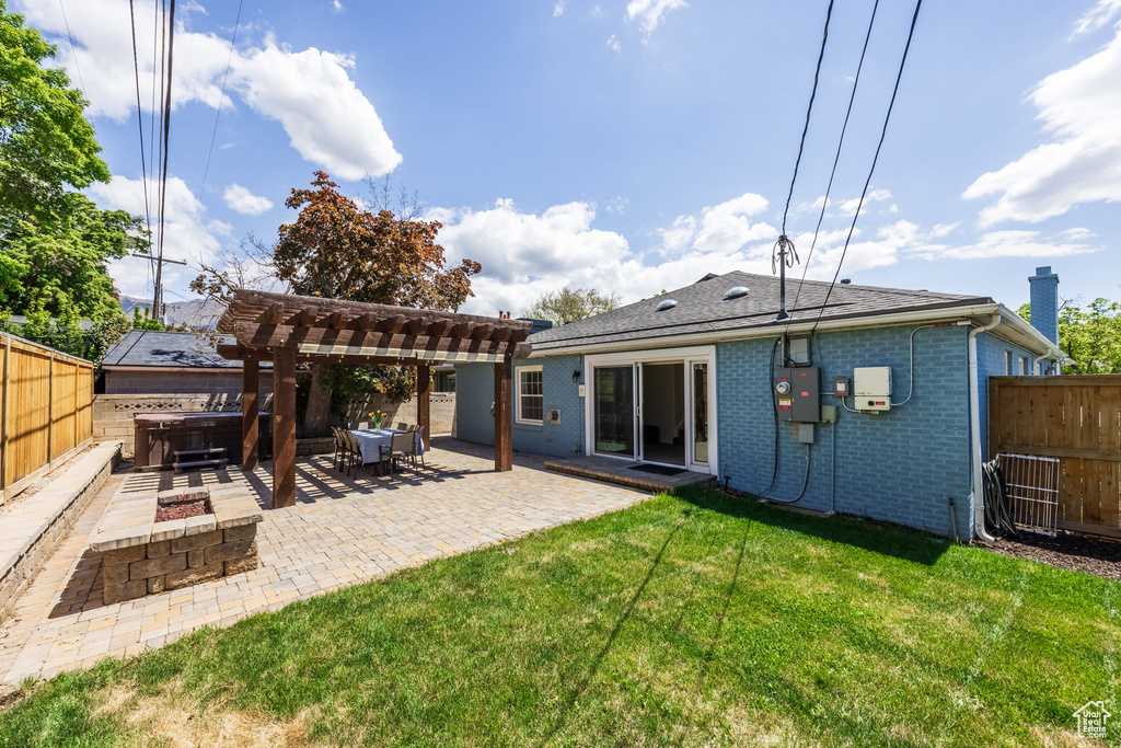 Rear view of property with a hot tub, a patio, a pergola, brick siding, and a shingled roof