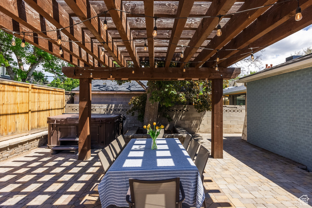 View of patio with a hot tub, a fenced backyard, and a pergola
