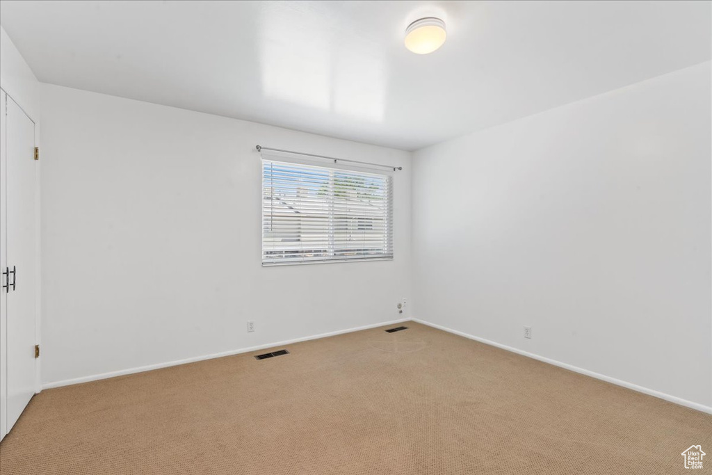 Carpeted spare room with baseboards