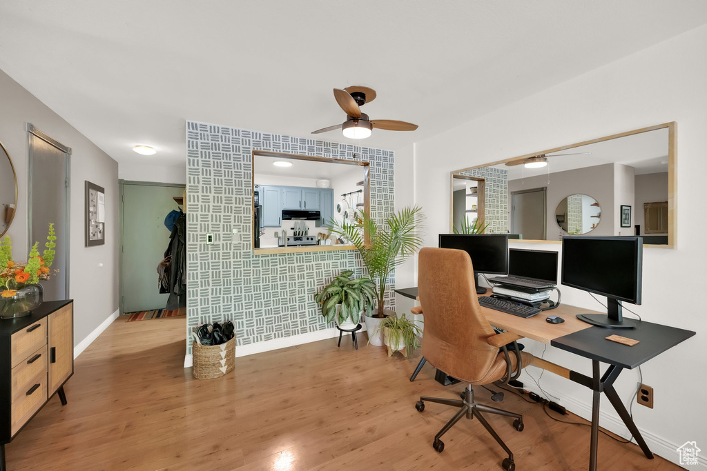 Office with ceiling fan, baseboards, light wood-style floors, and wallpapered walls