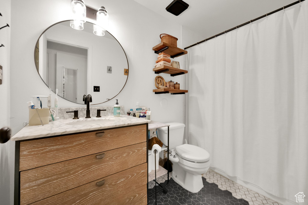 Full bath featuring toilet, vanity, tile patterned floors, and a shower with shower curtain