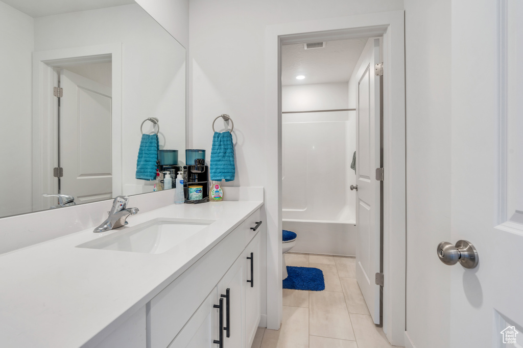 Bathroom with tile patterned floors, vanity, toilet, and  shower combination