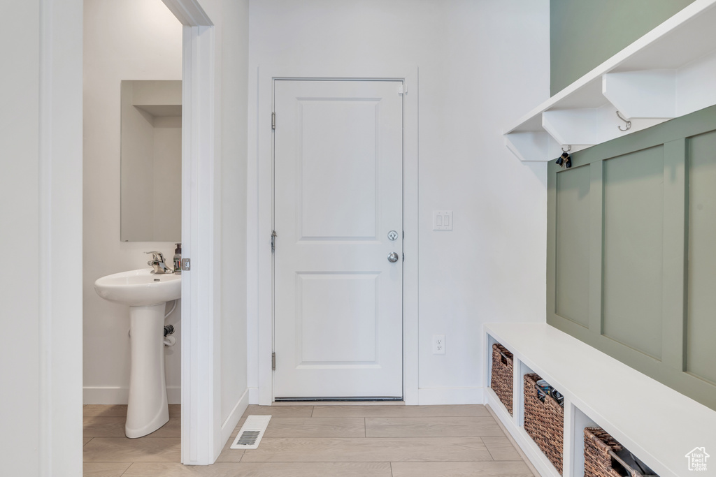 Mudroom featuring a sink and baseboards