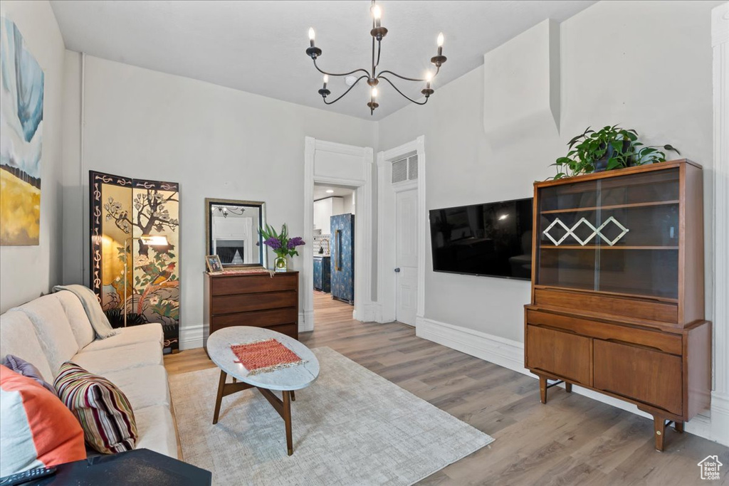 Living area featuring a chandelier, wood finished floors, and baseboards